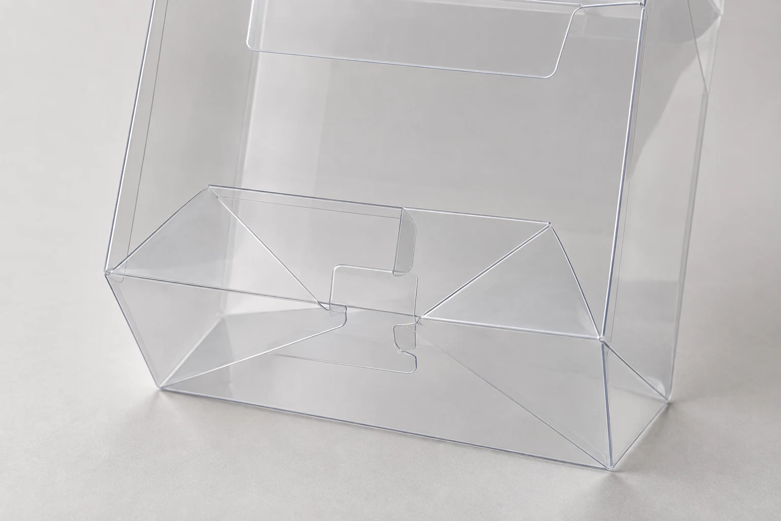 MUGE design-direction concept close-up of connected clear PET lock-bottom box folds