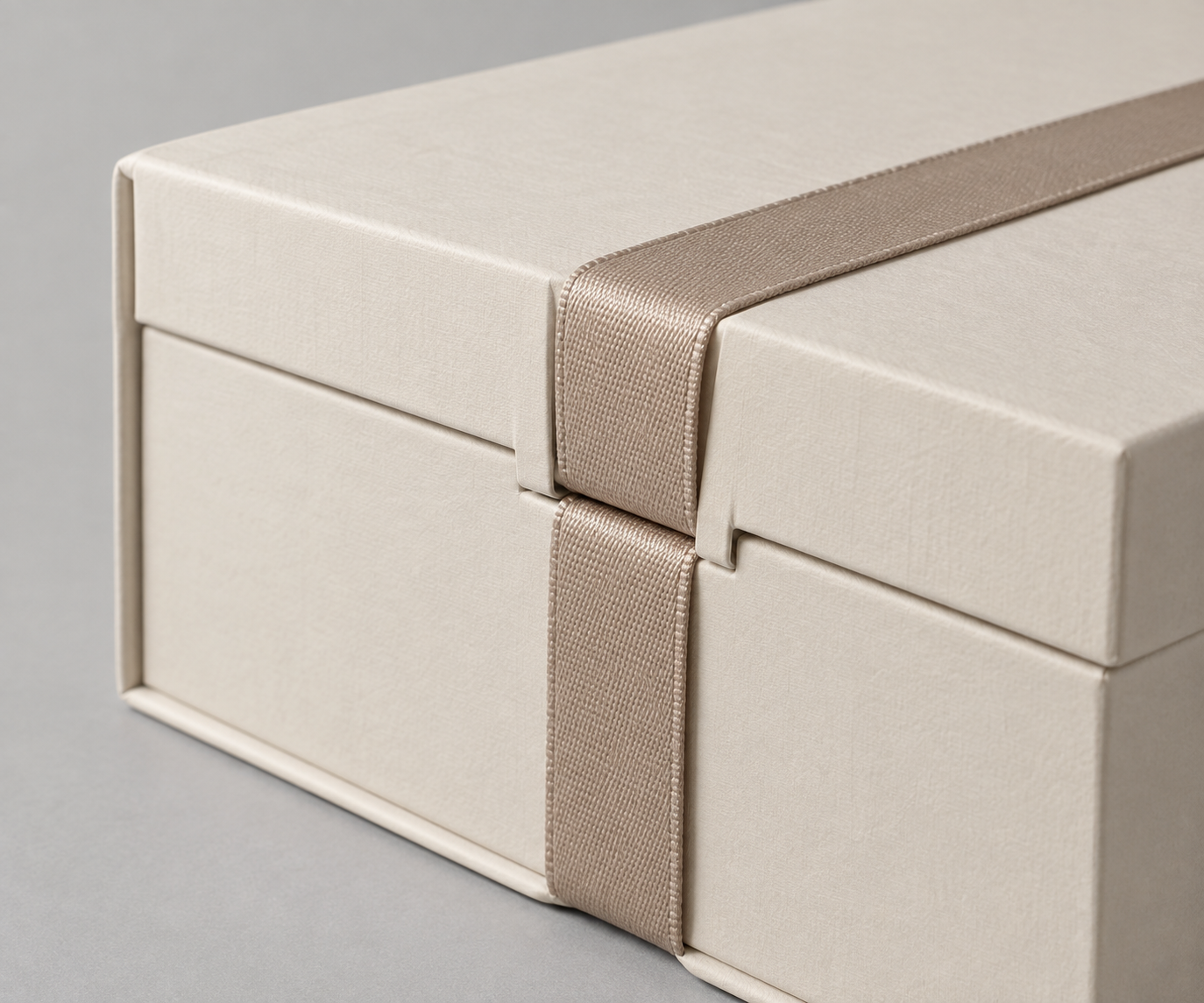 MUGE design-direction concept close-up of an unbranded ivory foldable gift box lid edge and ribbon placement