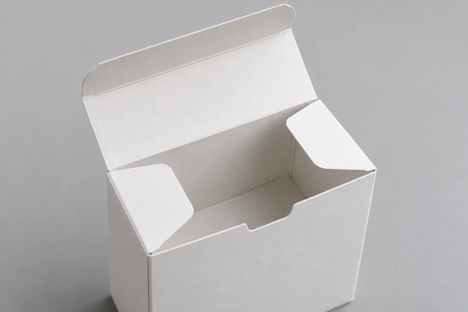 MUGE design-direction close-up of an open tuck-end folding carton with paperboard flaps