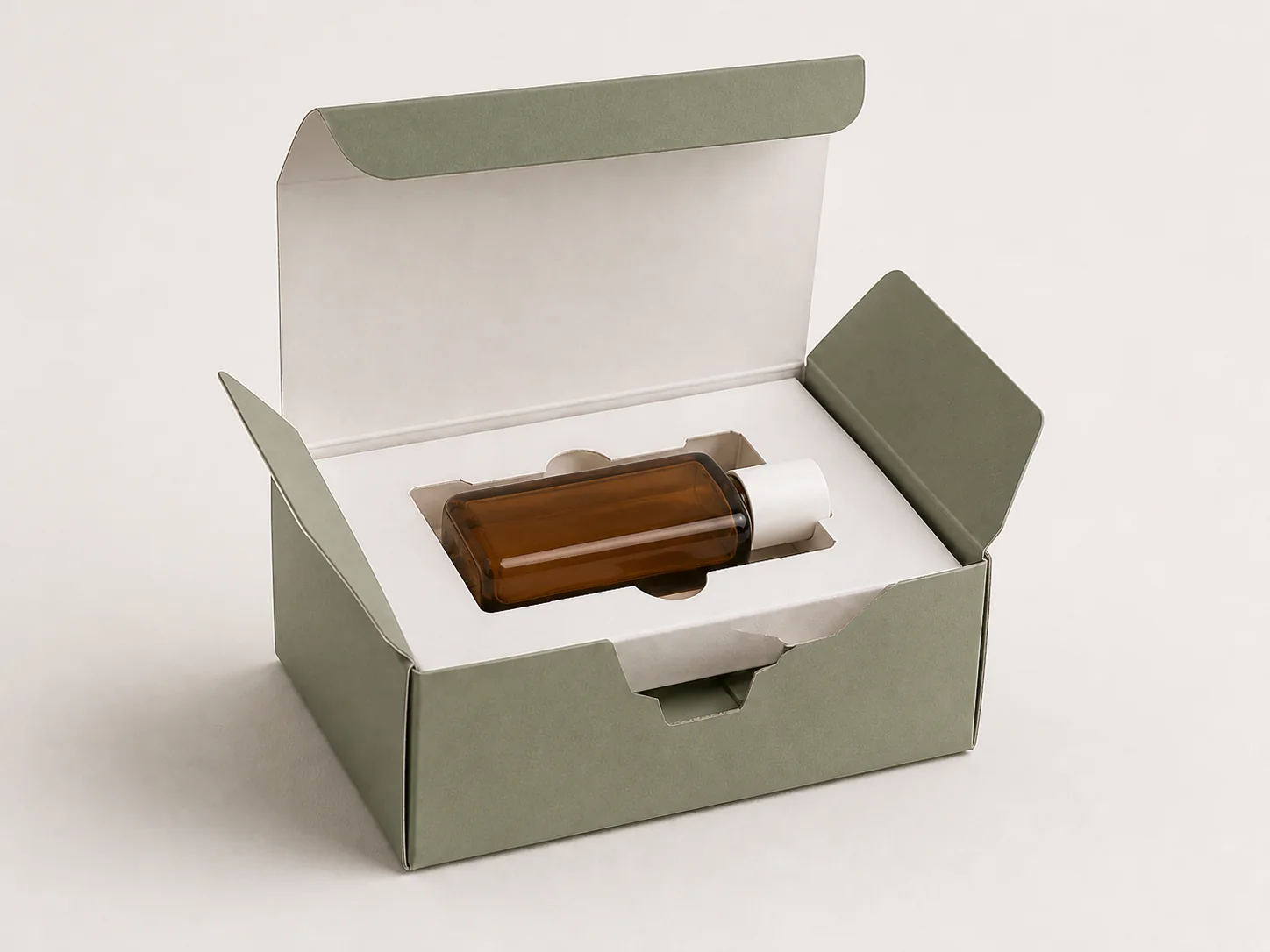 MUGE design-direction concept of an unbranded amber bottle illustratively fitted in a white paperboard insert inside a sage-green folding carton